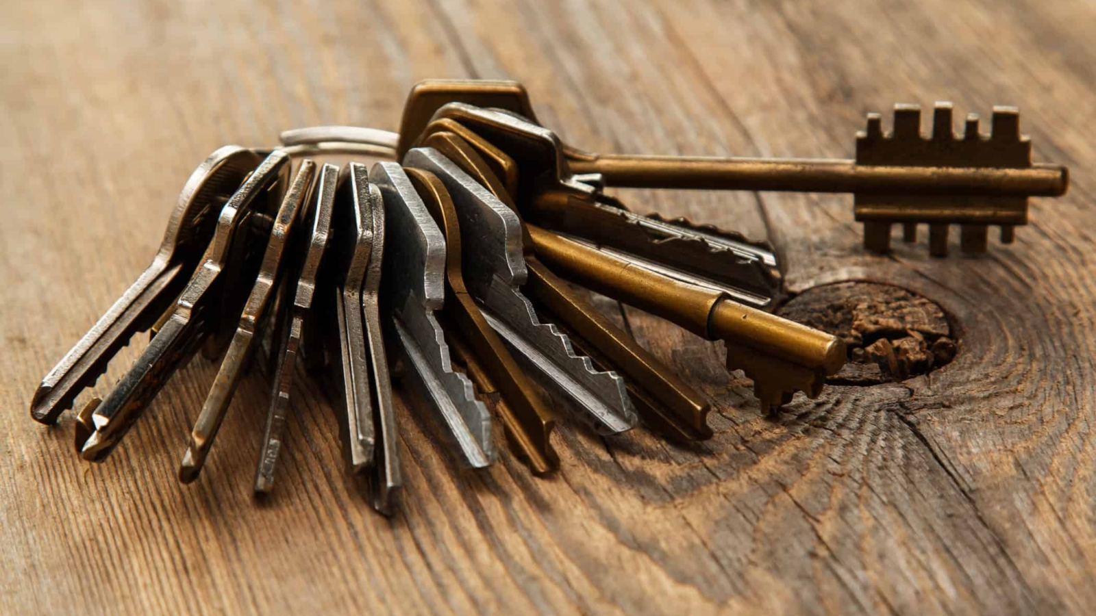 Bunch of different keys on wooden surface