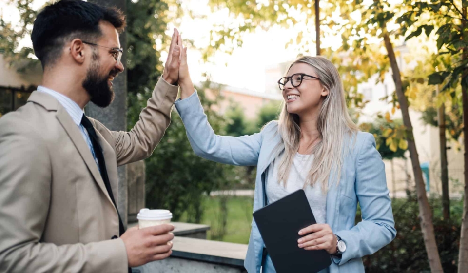 Business people giving high five outdoors after successful business deal